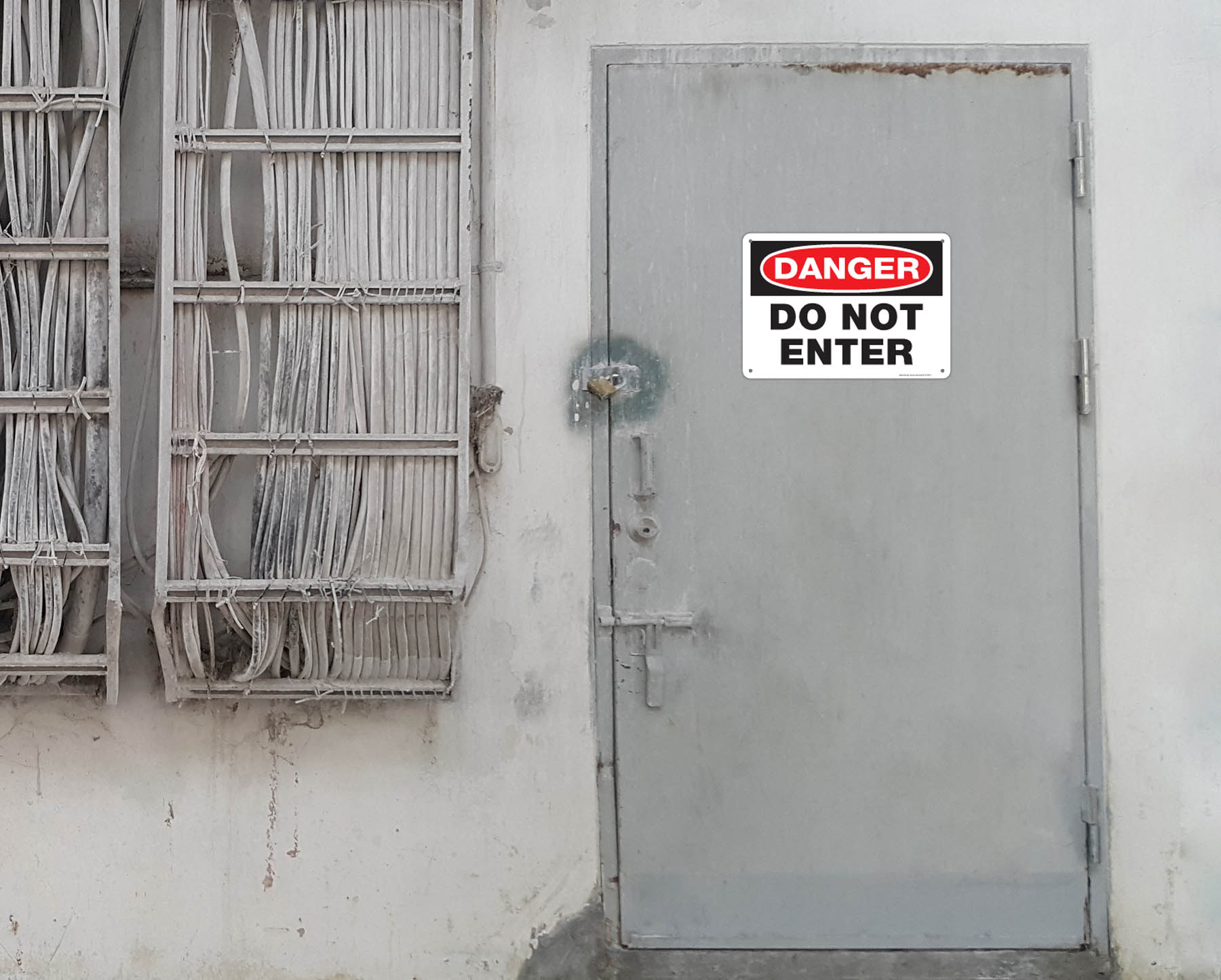 Danger Do Not Enter aluminum sign installed on metal door.