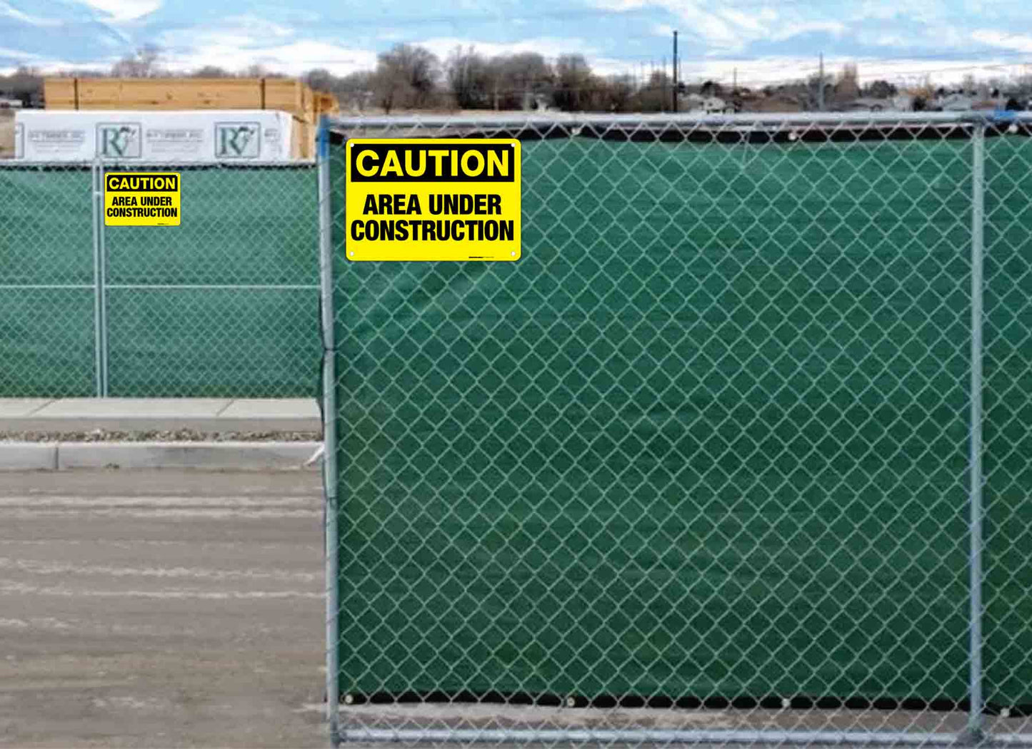 caution area under construction signs installed on fences.