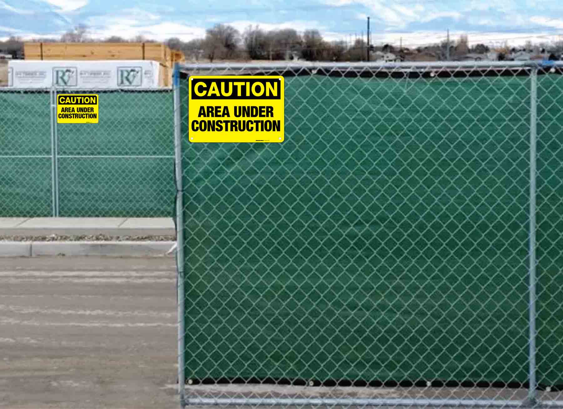 caution area under construction signs installed on fences.