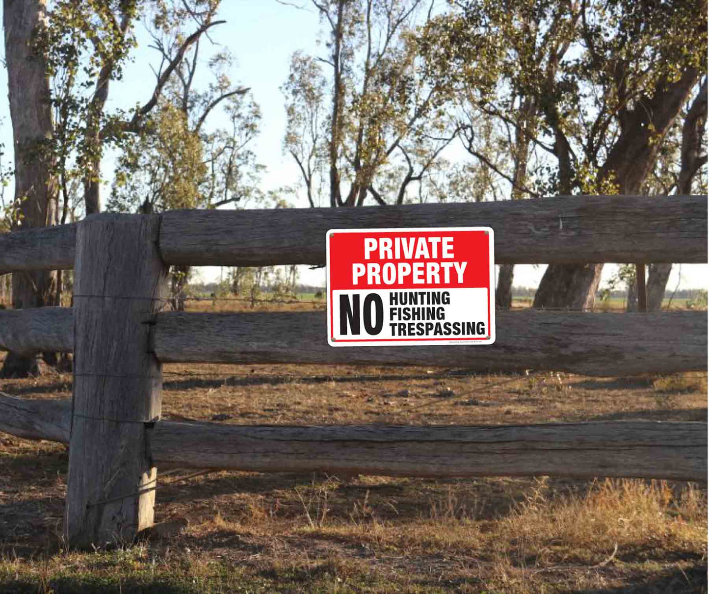 Private Property, No Hunting, No Fishing, No Trespassing aluminum sign and vinyl sticker signs installed on fence.
